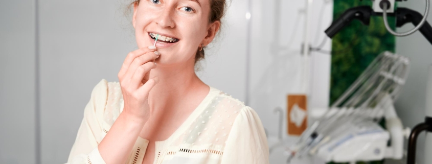 portrait-woman-with-braces-demonstrating-interdental-brushing